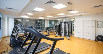 A bright empty gym with treadmills, fitness equipment and lockers