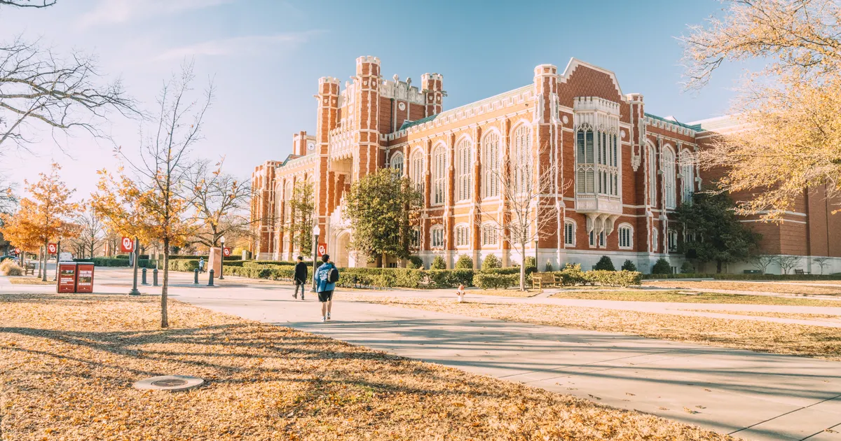 A brick university building surrounded by trees in autumn