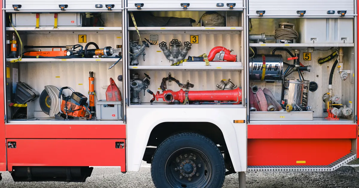 Open compartments on a fire engine showing neatly stored equipment
