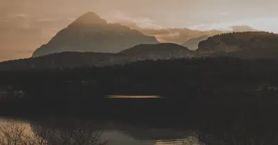 Layered mountain silhouettes above a quiet lake