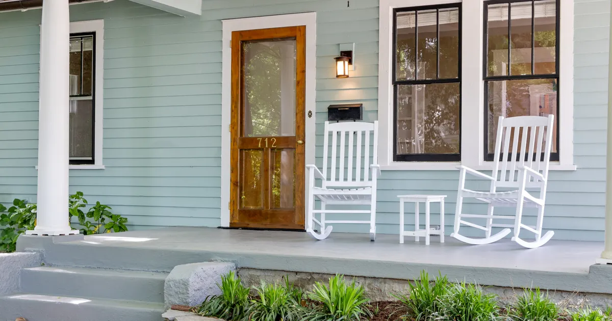 White rocking chairs on the covered front porch of a house